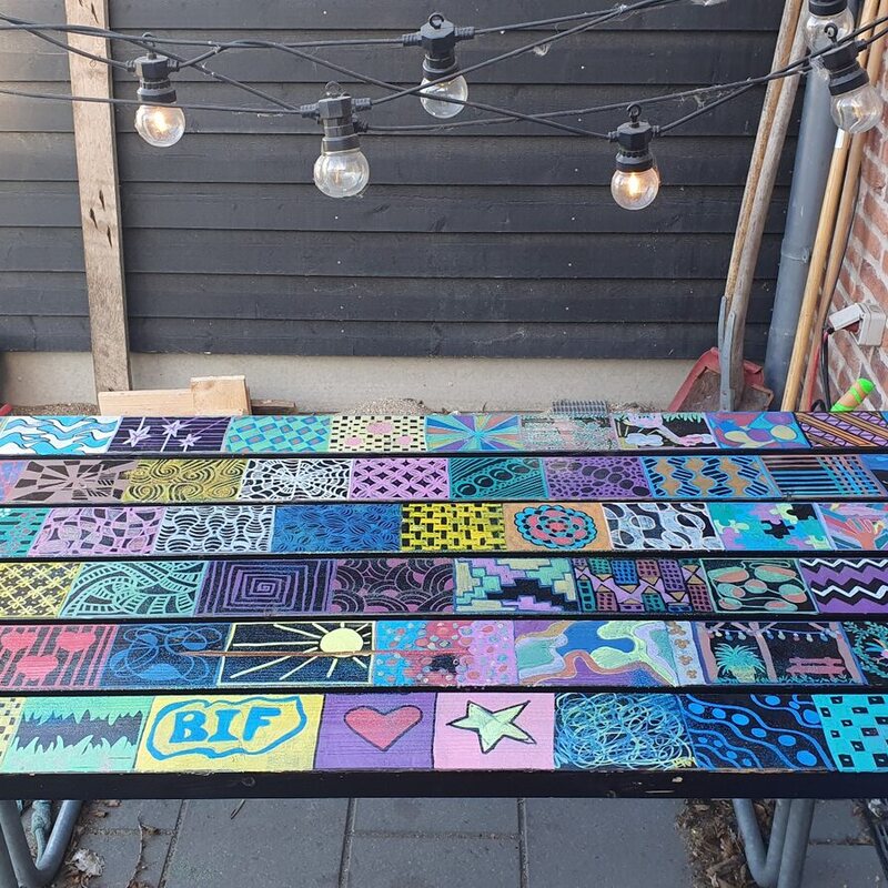 Et langt håndmalet doodlebord med mange farverige felter